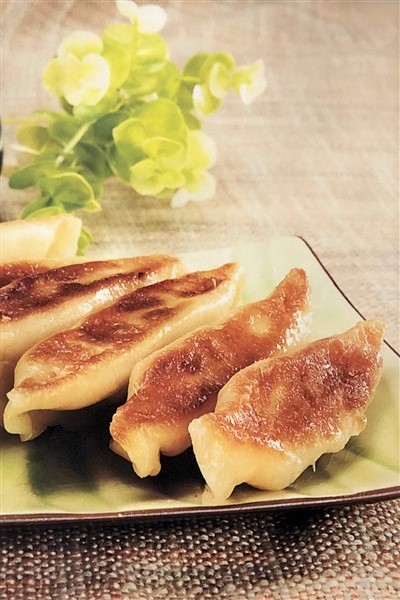 Delicious Chicken Stock Potstickers (Guo Tie) Held By Chinese Chopsticks