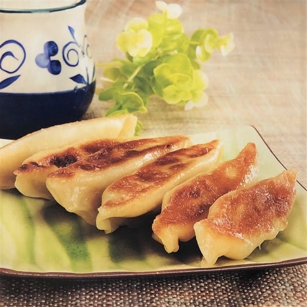 Delicious Chicken Stock Potstickers (Guo Tie) Held By Chinese Chopsticks
